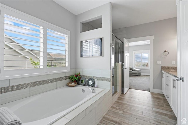6688 W Buck Dr, Herriman, UT 84096 - bathroom featuring vanity, a garden tub, a shower stall, and wood finished floors