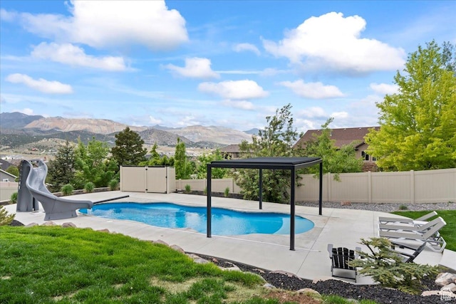 6688 W Buck Dr, Herriman, UT 84096 - view of swimming pool with a water slide, a patio area, and a mountain view