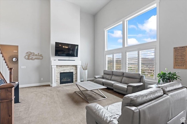 6688 W Buck Dr, Herriman, UT 84096 - carpeted living area featuring a high ceiling, stairs, a stone fireplace, and baseboards