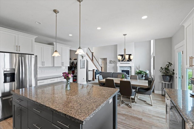 6688 W Buck Dr, Herriman, UT 84096 - kitchen featuring stainless steel fridge with ice dispenser, backsplash, white cabinetry, recessed lighting, and light wood-style flooring