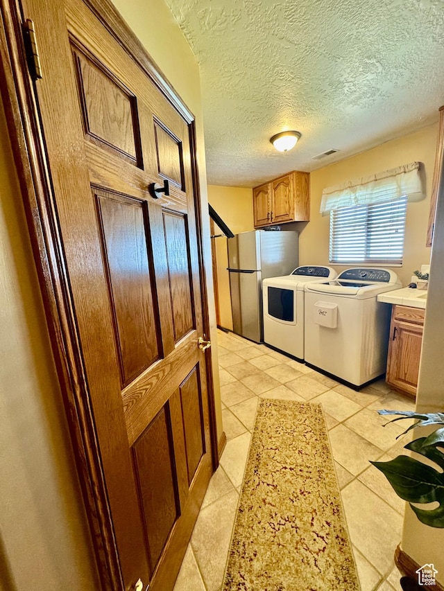1660 E 900 S Unit 19, Clearfield, UT 84015 - kitchen with freestanding refrigerator, washing machine and clothes dryer, light countertops, light tile patterned flooring, and brown cabinets