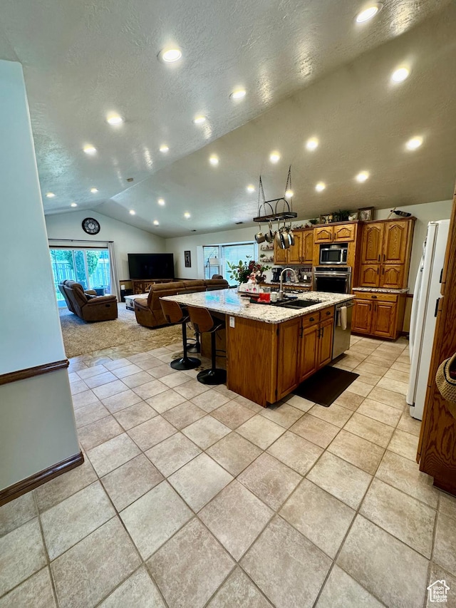 1660 E 900 S Unit 19, Clearfield, UT 84015 - kitchen with appliances with stainless steel finishes, vaulted ceiling, open floor plan, a large island with sink, and brown cabinets