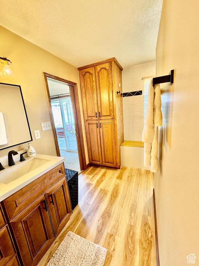 1660 E 900 S Unit 19, Clearfield, UT 84015 - bathroom featuring a textured ceiling, wood finished floors, vanity, a tub, and a shower
