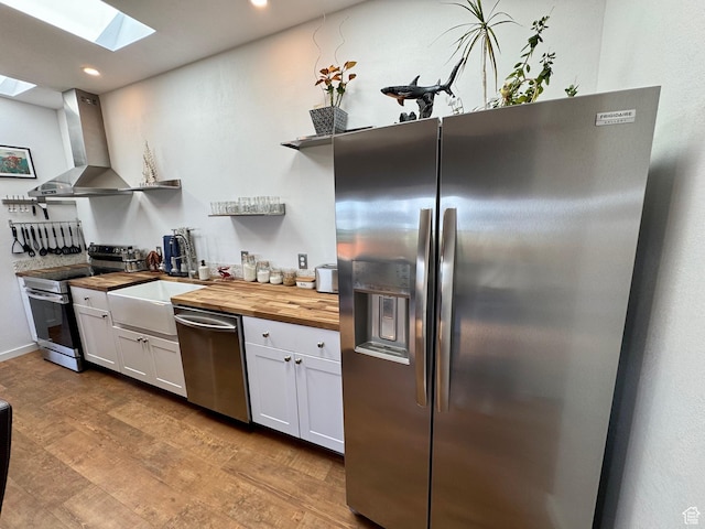357 Juniper Dr Unit 480, Fish Haven, ID 83287 - kitchen with appliances with stainless steel finishes, butcher block countertops, open shelves, a skylight, and wall chimney exhaust hood