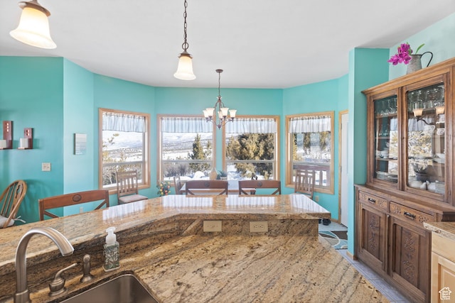 14434 N 11550 E, Mount Pleasant, UT 84647 - kitchen featuring a sink, a chandelier, hanging light fixtures, light stone counters, and glass insert cabinets
