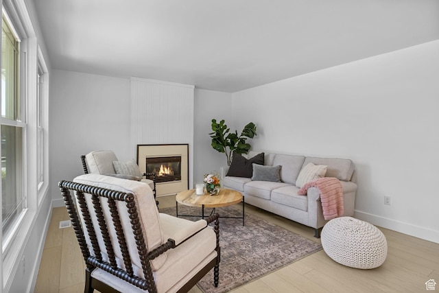 9224 S Benson Way, Sandy, UT 84070 - living area featuring wood finished floors, healthy amount of natural light, a glass covered fireplace, and baseboards