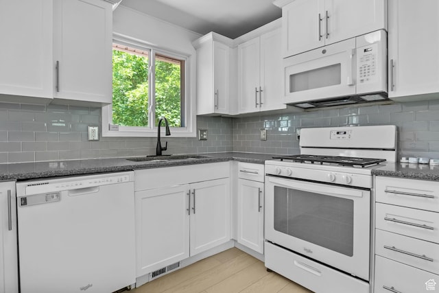 9224 S Benson Way, Sandy, UT 84070 - kitchen with white appliances, a sink, white cabinets, dark stone counters, and backsplash