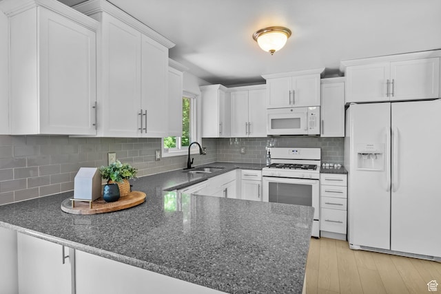 9224 S Benson Way, Sandy, UT 84070 - kitchen featuring white appliances, a sink, white cabinets, a peninsula, and dark stone counters
