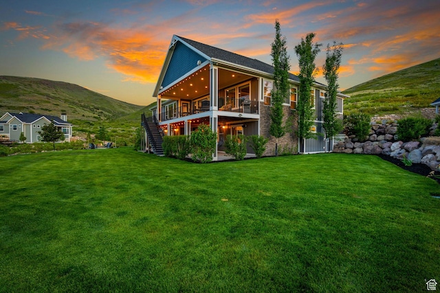 15113 S Cedar Meadow Cir, Herriman, UT 84096 - back of property at dusk featuring stairs, a yard, and a deck with mountain view