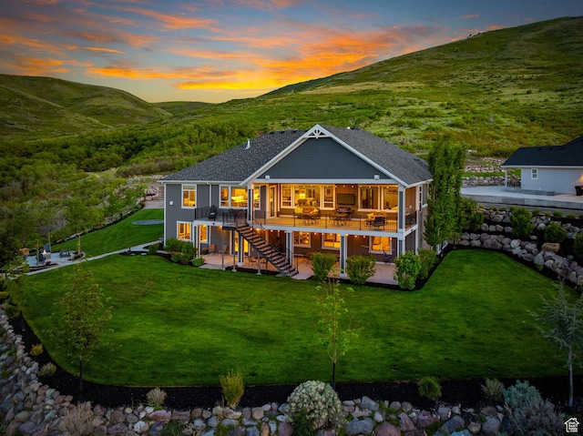 15113 S Cedar Meadow Cir, Herriman, UT 84096 - back of property at dusk featuring stairs, a patio, a deck with mountain view, and a yard