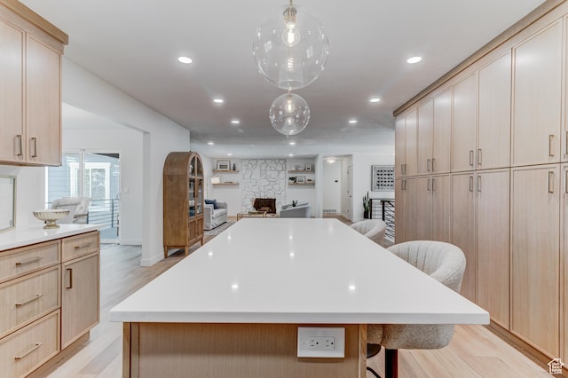 7474 S Brighton Way, Cottonwood Heights, UT 84121 - kitchen with light brown cabinetry, open floor plan, recessed lighting, a breakfast bar, and light wood-style floors