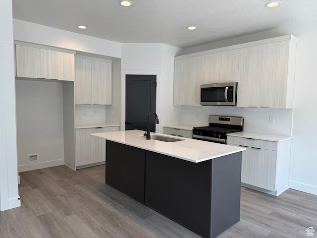 3664 S 4600 W Unit 222, West Haven, UT 84401 - kitchen with stainless steel appliances, modern cabinets, a sink, light countertops, and light wood-type flooring