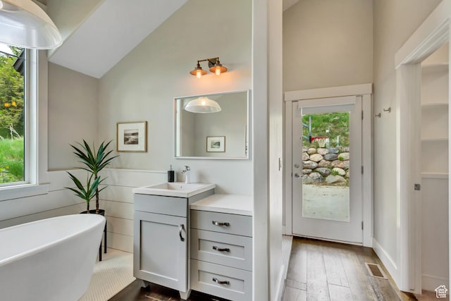 1685 N 300 E, Midway, UT 84049 - bathroom with vanity, a soaking tub, wood-type flooring, high vaulted ceiling, and healthy amount of natural light