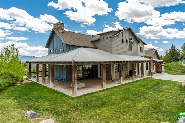 1685 N 300 E, Midway, UT 84049 - rear view of house featuring board and batten siding, a patio area, a lawn, and a chimney