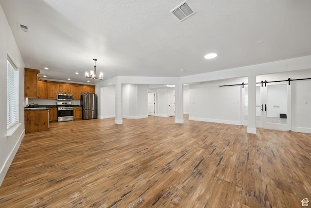 3444 N 180 E, Provo, UT 84604 - unfurnished living room featuring a barn door, a chandelier, wood finished floors, baseboards, and recessed lighting