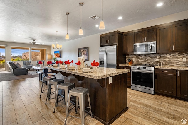 3800 Paradise Village Dr Unit 84, Santa Clara, UT 84765 - kitchen with appliances with stainless steel finishes, open floor plan, light wood-style floors, tasteful backsplash, and recessed lighting