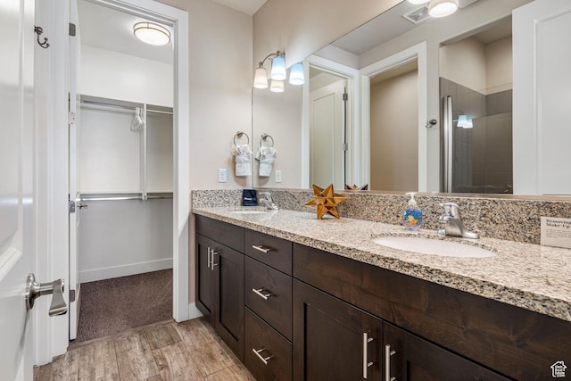 3800 Paradise Village Dr Unit 84, Santa Clara, UT 84765 - bathroom with double vanity, a shower stall, wood finished floors, and a walk in closet