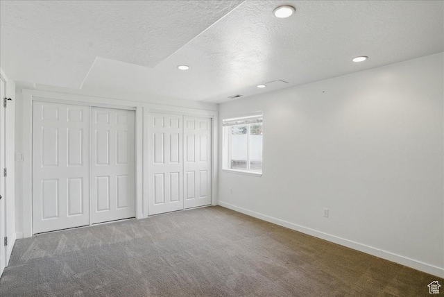 5167 N Rodeo Cir Unit 6, Oakley, UT 84055 - unfurnished bedroom with carpet flooring, a textured ceiling, baseboards, recessed lighting, and two closets