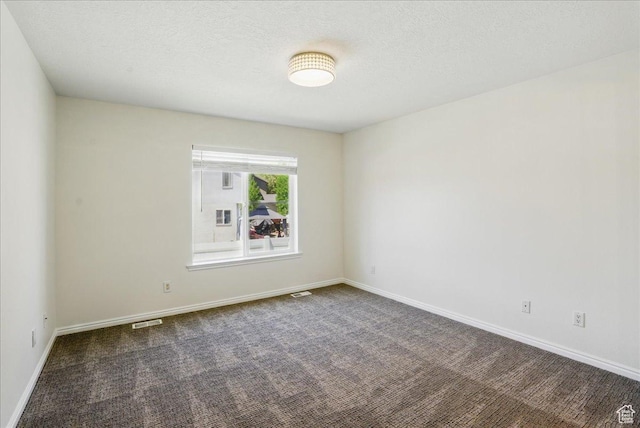 5167 N Rodeo Cir Unit 6, Oakley, UT 84055 - empty room featuring dark carpet, baseboards, and a textured ceiling