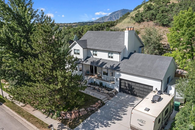 10927 S Lostwood Dr, Sandy, UT 84092 - view of front of home with a chimney, a shingled roof, a garage, concrete driveway, and a mountain view