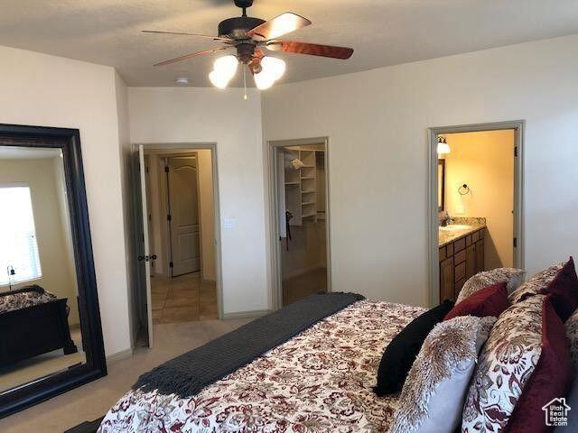 779 S 1850 W, Cedar City, UT 84720 - bedroom with light colored carpet, a spacious closet, a ceiling fan, ensuite bathroom, and a closet