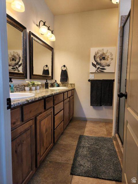 779 S 1850 W, Cedar City, UT 84720 - full bathroom featuring double vanity, a stall shower, and baseboards