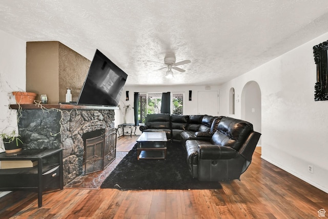 4825 S Burch Creek Dr E, South Ogden, UT 84403 - living room with arched walkways, ceiling fan, hardwood / wood-style floors, a textured ceiling, and a fireplace