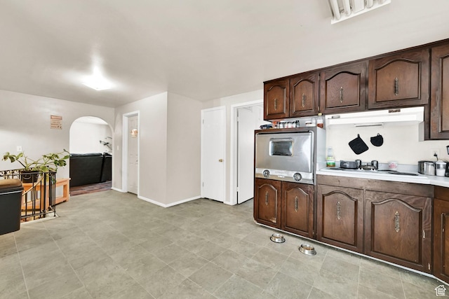 4825 S Burch Creek Dr E, South Ogden, UT 84403 - kitchen featuring oven, under cabinet range hood, arched walkways, white cooktop, and dark brown cabinets