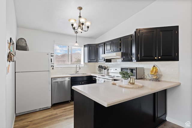 429 S Storrs Ave, American Fork, UT 84003 - kitchen featuring appliances with stainless steel finishes, a sink, under cabinet range hood, a peninsula, and vaulted ceiling
