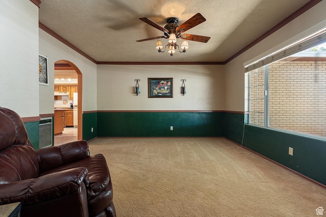 845 S 80 W, Hurricane, UT 84737 - living area featuring light colored carpet, ceiling fan, ornamental molding, a wainscoted wall, and a textured ceiling