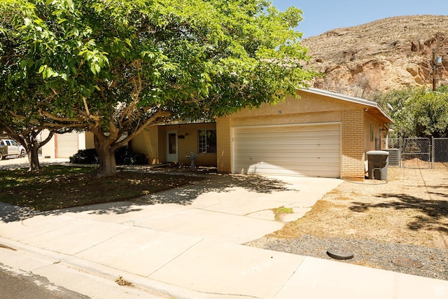 845 S 80 W, Hurricane, UT 84737 - obstructed view of property featuring brick siding, concrete driveway, an attached garage, and a mountain view
