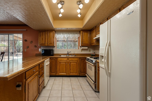 845 S 80 W, Hurricane, UT 84737 - kitchen featuring white fridge with ice dispenser, range with gas stovetop, brown cabinetry, black microwave, and a peninsula