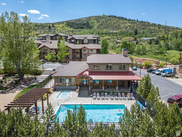 5430 N Cross Country Way, Park City, UT 84098 - rear view of house featuring a chimney, a fenced backyard, a mountain view, a community pool, and a patio area