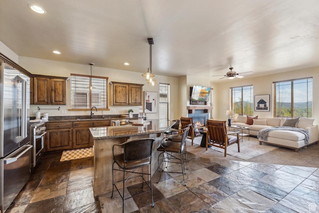 5430 N Cross Country Way, Park City, UT 84098 - kitchen featuring premium appliances, a kitchen island, stone tile flooring, a kitchen bar, and a sink