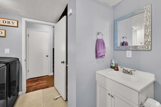 5443 S 4175 W, Roy, UT 84067 - bathroom featuring washer and dryer, vanity, a textured ceiling, and wood finished floors