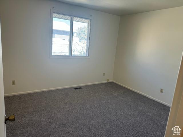3165 S Green St, Salt Lake City, UT 84106 - spare room with dark colored carpet and baseboards