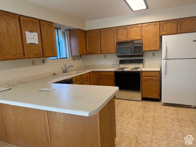 3165 S Green St, Salt Lake City, UT 84106 - kitchen featuring white appliances, brown cabinets, a peninsula, and light countertops