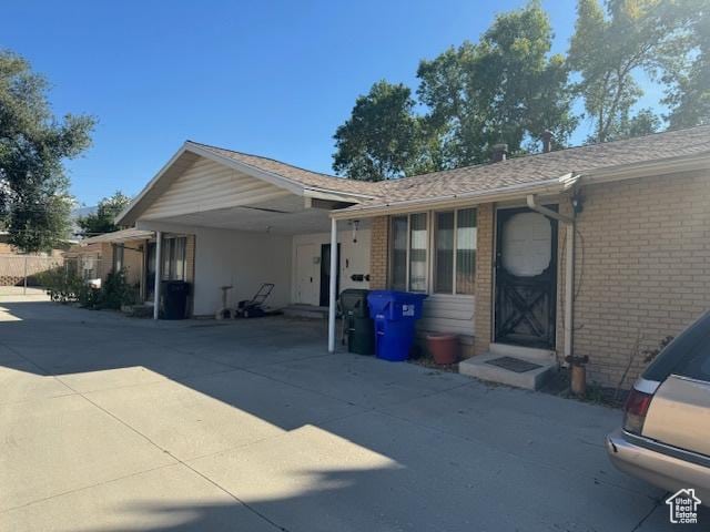3165 S Green St, Salt Lake City, UT 84106 - view of front facade featuring a carport, brick siding, and concrete driveway