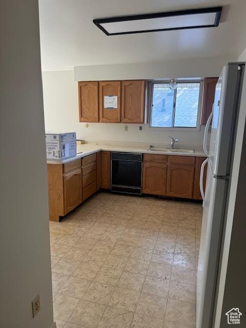 3165 S Green St, Salt Lake City, UT 84106 - kitchen with freestanding refrigerator, dishwasher, a sink, brown cabinetry, and light countertops