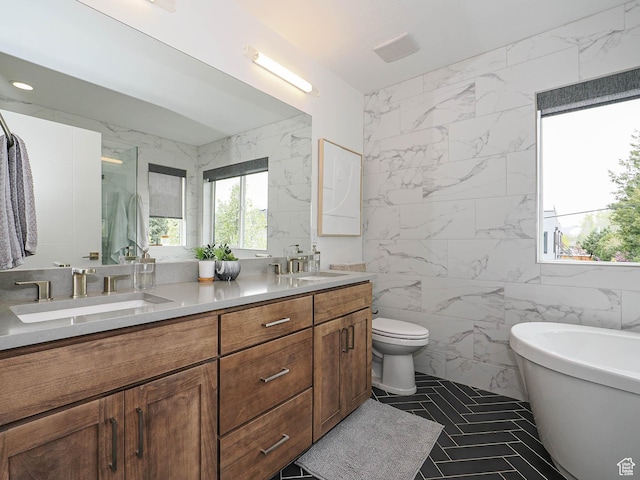 4535 S Bleecker Pl, Millcreek, UT 84117 - bathroom with tile walls, double vanity, a freestanding bath, toilet, and an enclosed shower