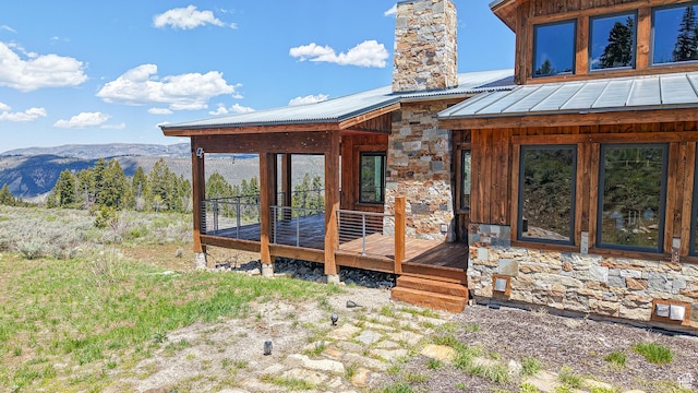 22677 E Snowbird Dr Unit 47, Spanish Fork, UT 84660 - doorway to property featuring a chimney, stone siding, a deck with mountain view, and metal roof