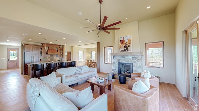 22677 E Snowbird Dr Unit 47, Spanish Fork, UT 84660 - living room featuring light wood-style flooring, ceiling fan, recessed lighting, a stone fireplace, and a towering ceiling