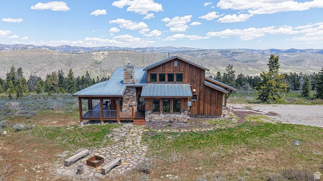 22677 E Snowbird Dr Unit 47, Spanish Fork, UT 84660 - rustic home with a chimney, a deck with mountain view, metal roof, stone siding, and a standing seam roof