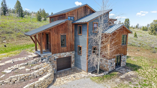22677 E Snowbird Dr Unit 47, Spanish Fork, UT 84660 - back of house with stone siding, a standing seam roof, an attached garage, and metal roof