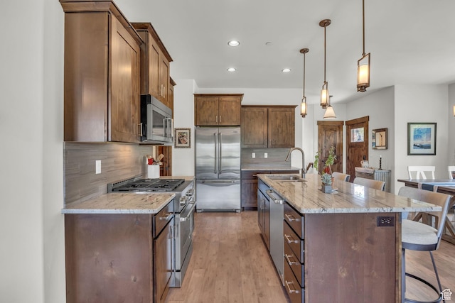 1009 W White Cloud Trl, Kamas, UT 84036 - kitchen featuring appliances with stainless steel finishes, a breakfast bar area, a sink, recessed lighting, and decorative backsplash