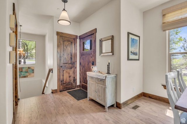 1009 W White Cloud Trl, Kamas, UT 84036 - entrance foyer with light wood-style flooring, healthy amount of natural light, a chandelier, and baseboards