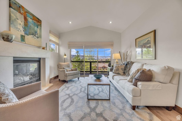1009 W White Cloud Trl, Kamas, UT 84036 - living area featuring wood finished floors, healthy amount of natural light, vaulted ceiling, a glass covered fireplace, and baseboards