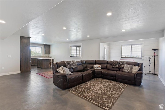 1243 Kotter Dr, Brigham City, UT 84302 - living area featuring concrete flooring, recessed lighting, baseboards, healthy amount of natural light, and a textured ceiling