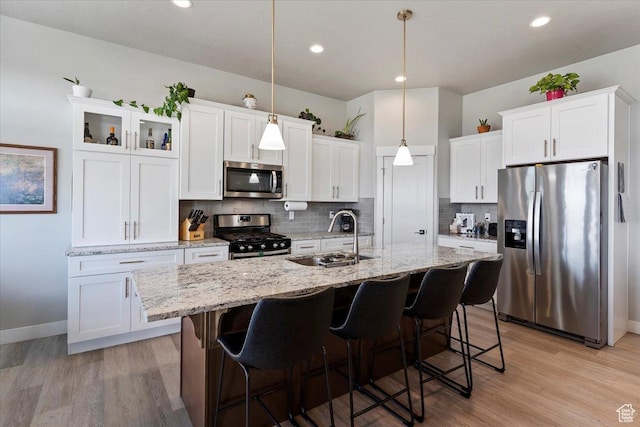 1243 Kotter Dr, Brigham City, UT 84302 - kitchen with appliances with stainless steel finishes, a sink, white cabinets, an island with sink, and tasteful backsplash