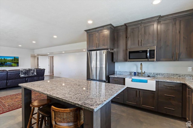 1243 Kotter Dr, Brigham City, UT 84302 - kitchen with appliances with stainless steel finishes, a sink, finished concrete flooring, dark brown cabinets, and open floor plan